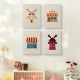 The four Windmill Village mini canvases on a wall above a shelf