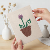 Hand holding a finished Windowsill Blooms mini canvas