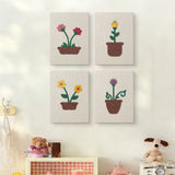 The four Windowsill Blooms mini canvases on a wall above a shelf