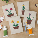 The four finished Windowsill Blooms mini canvases laid out on a table