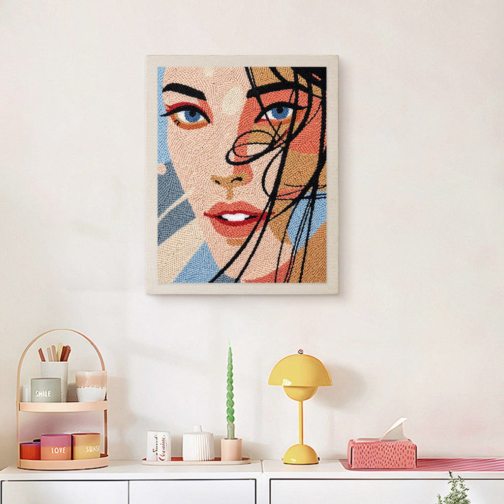 Finished Windswept Hair punch needle canvas on a wall