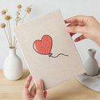 Hand holding a finished Winged Heart Mix mini canvas