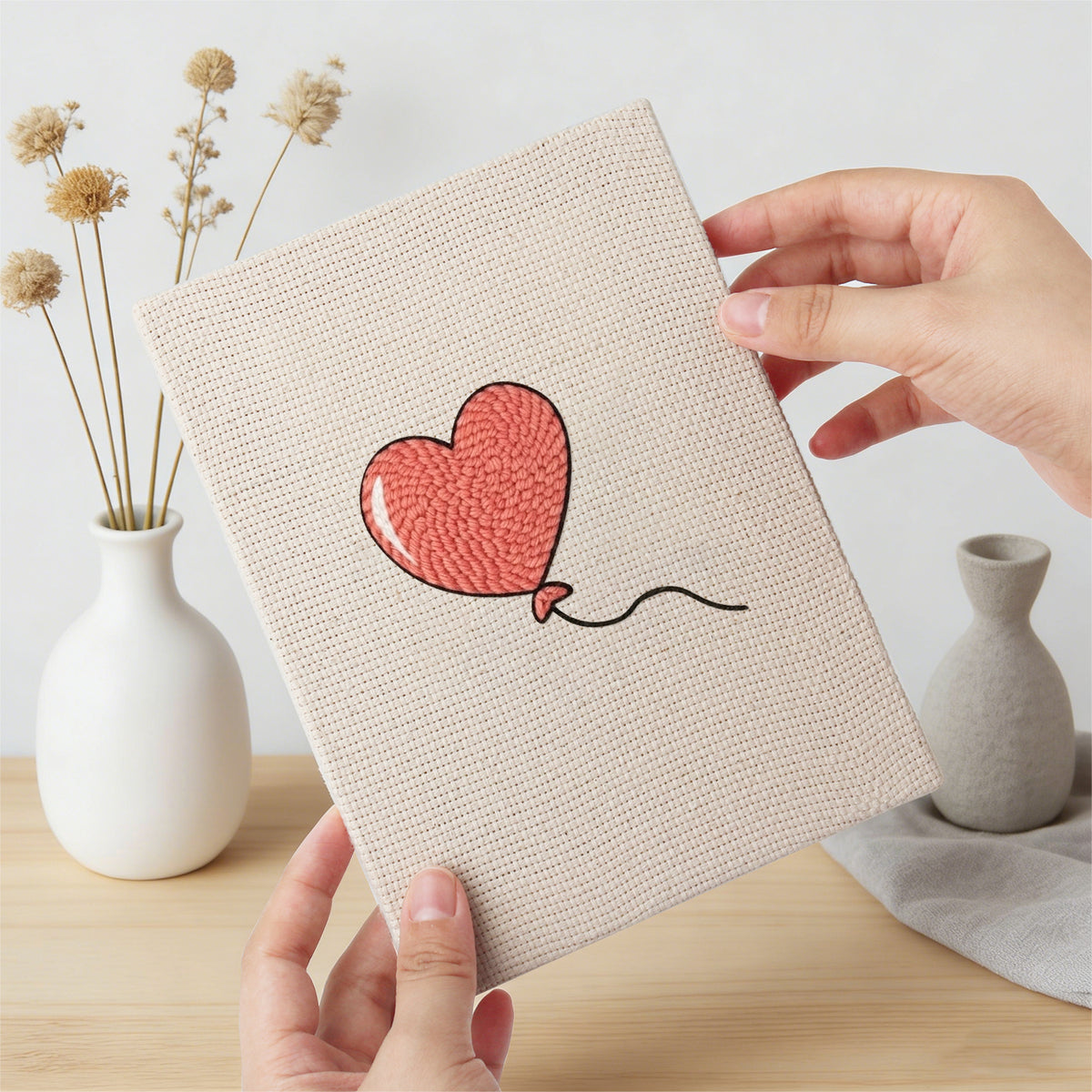 Hand holding a finished Winged Heart Mix mini canvas