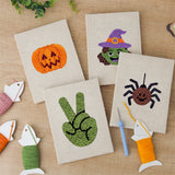 The four finished Witch and Spider mini canvases laid out on a table