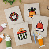 The four finished Wreath and Bell mini canvases laid out on a table