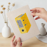 Hand holding a finished Yellow Binder Office mini canvas