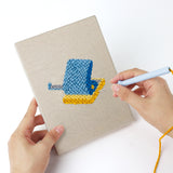 Punching a Yellow Binder Office mini canvas with the punch needle