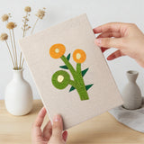Hand holding a finished Yellow Folk Flowers mini canvas