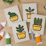 The four finished Yellow Pot Cacti mini canvases laid out on a table