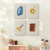 The four Yellow Scissors Desk mini canvases on a wall above a shelf