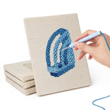Hand punching one of the Yellow Scissors Desk mini canvases