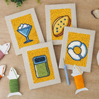 The four finished Yellow Sundae Glass mini canvases laid out on a table
