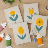 The four finished Yellow Tulip Patch mini canvases laid out on a table
