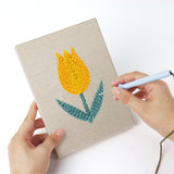 Punching a Yellow Tulip Patch mini canvas with the punch needle