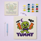 Yummy Candy Monster canvas before and after punching, with the threads and tools